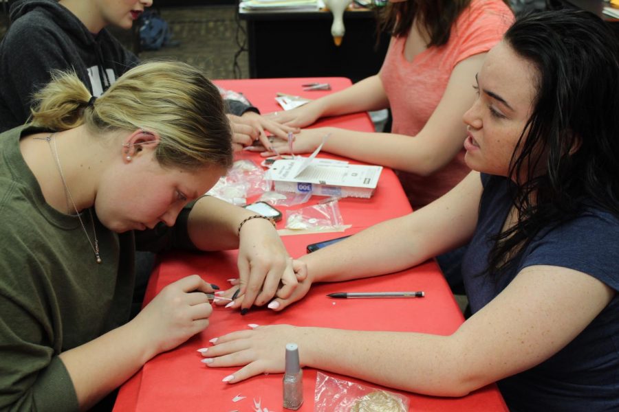Ally Davis (11) paints Alexis Wilsons (11) nails. Davis volunteered to help with Operation Cinderella, which started with hair and makeup at 9 a.m. Saturday Dec. 15. 