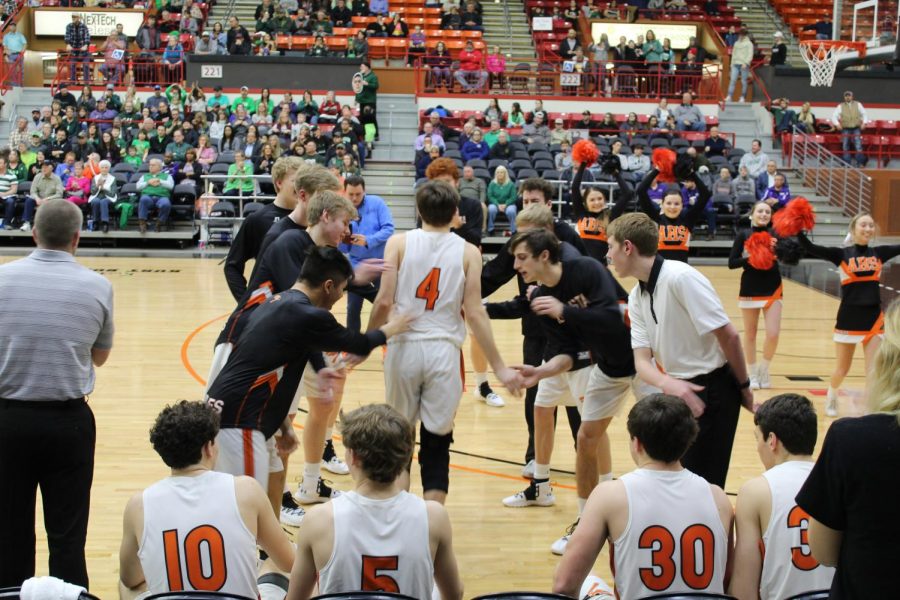 Blake+Altenhofen+%2812%29%2C+getting+ready+to+play+his+last+basketball+game%2C+high+fives+his+teammates.+The+boys+basketball+team+ended+the+season+placing+second+in+the+state+tournament.+