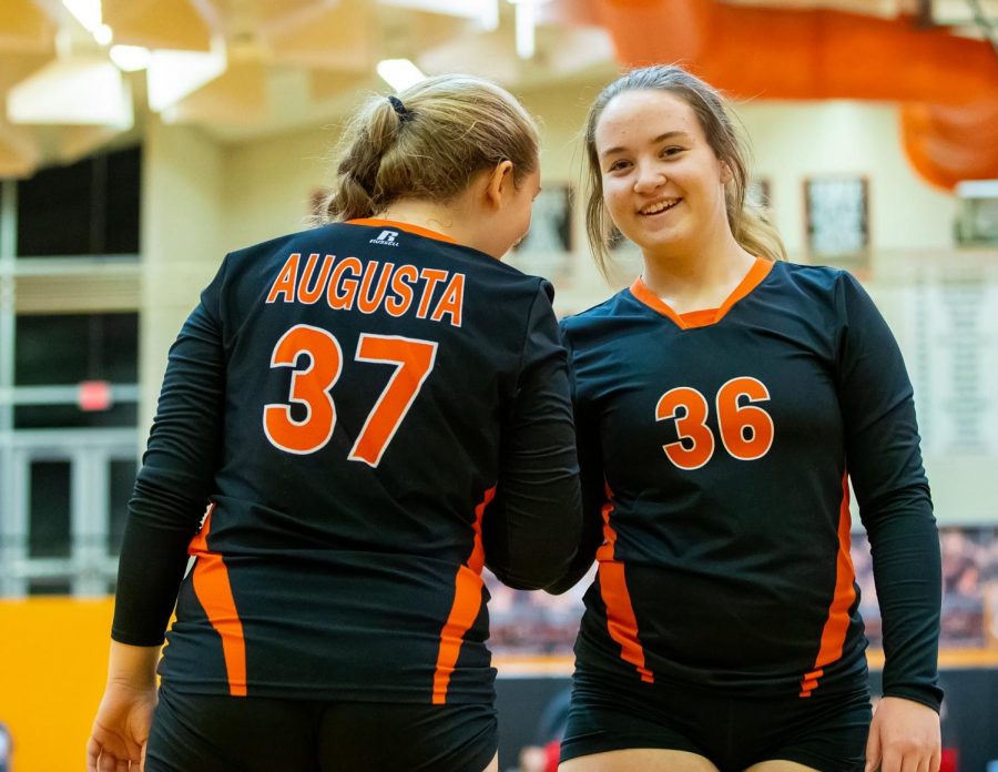 Freshman Alli Eastridge motivates her teammate Jenna Speere at their volleyball game. The team worked together to get the victory.
