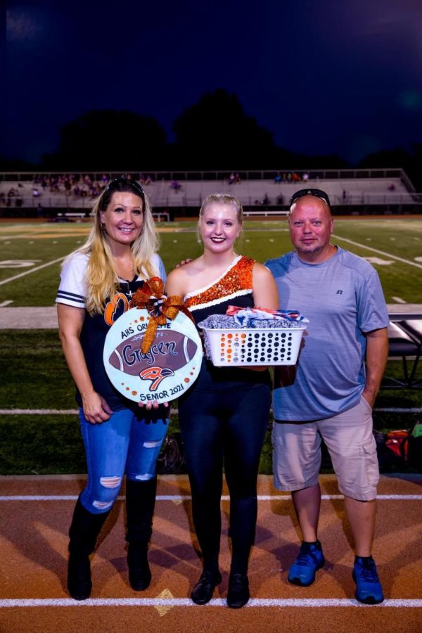 Senior Graycen Elliott stands with her parents during halftime of the football game. Elliott’s biggest accomplishment in dance is that her skills have grown immensely over the years and that she is now the captain of the team.