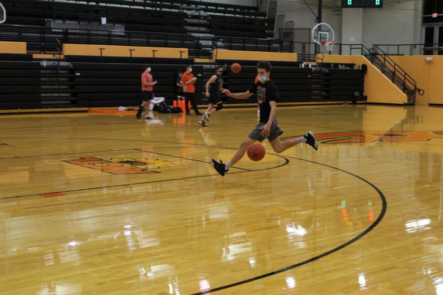 Senior Xander Roberts tries out for the basketball team Nov. 17 in the Hutter Gym. He goes in for a layup and makes it.