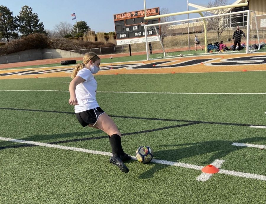 Freshman+Peyton+Childers+shoots+the+ball+before+soccer+practice+while+warming+up.+The+varsity+girls%E2%80%99+first+game+will+be+March+22+at+home+against+Mulvane+at+6%3A30+p.m.+