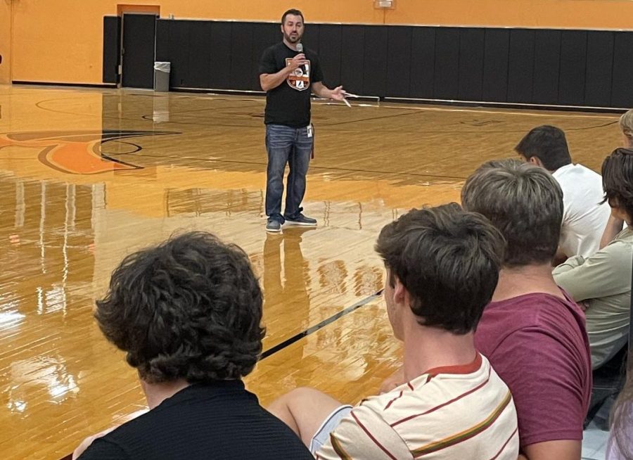 Assistant principal TJ Meyer talks to the senior class about taking advantage of high school through extracurricular activities. With the instruction of Meyer, eight seniors played a game, which required them to throw their shoes before running to retrieve the matches relay-style. 