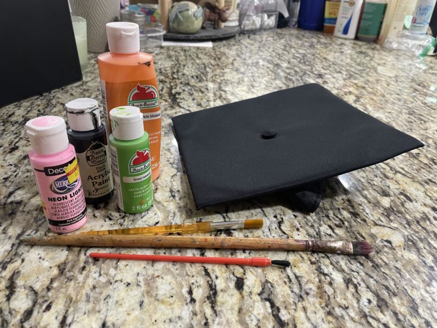 Art+supplies+sit+near+an+empty+graduation+cap.+Currently%2C+students+are+not+allowed+to+wear+decorated+caps+to+the+formal+graduation+ceremony.+