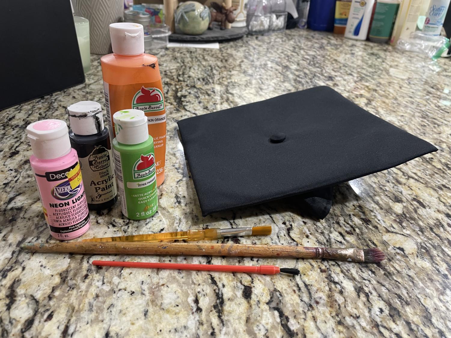 Art supplies sit near an empty graduation cap. Currently, students are not allowed to wear decorated caps to the formal graduation ceremony. 
