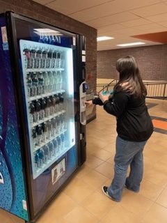  Junior Pashence Adkins gets a Blue Mystery Fanta. The Coca Cola company owns and operates the drink vending machines while Premier Foods updates and owns the snack vending machines. 