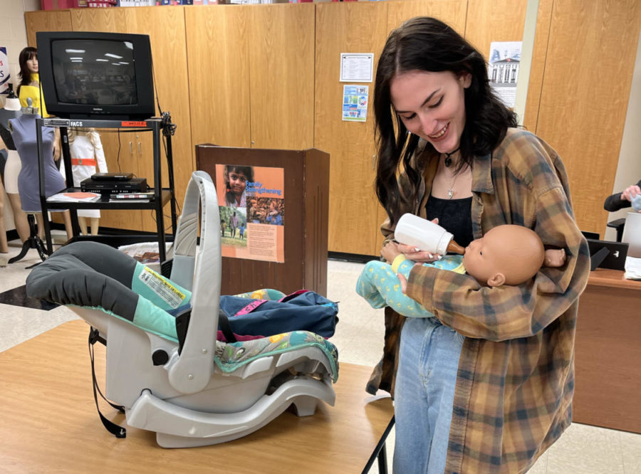 Senior Breanna Latimer learns how to care for the electronic baby in her class human growth and development. As she tries to calm the baby from crying, she learns the proper way to feed the baby.