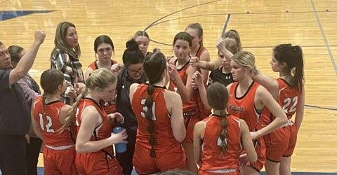 The girls basketball team joins together during time-out to discuss the game. The girls team is currently at a 4-5 score.
