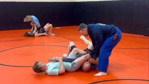 Dalton Pankrats has one of the coaches in an arm bar. Meckle is observing for scoring