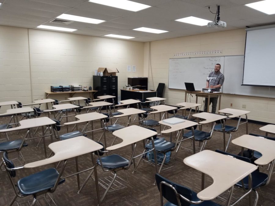  Math teacher Jonathan Morgan prepares for his college algebra class after lunch. Morgan’s classroom does not have the ability to dim lights so his lights are often bright as well as not having access to windows in the class.