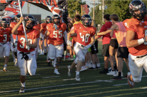 Members of the varsity football team run onto the field before the game against Chanute Sept. 20. The football team and other sports teams have struggled to involve athletes in their programs. photo credit Mason Edwards