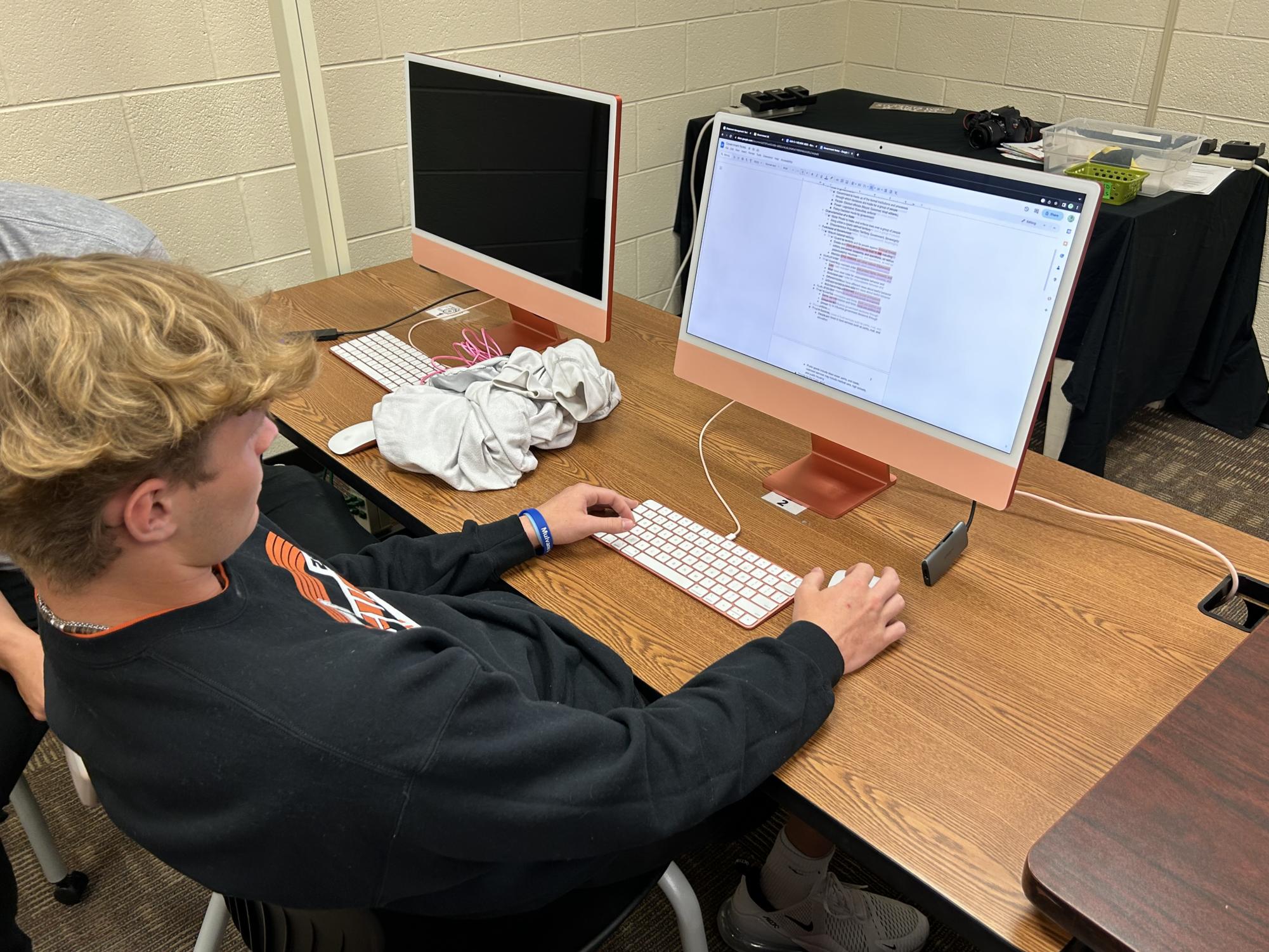 Senior Isaiah Blackwell works on the desktops in Audra Shelites classroom. Blackwell and Shelite have been working closely together to improve Blackwells photography.