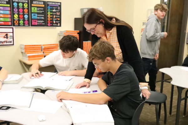 English Teacher Kristine Price helps freshman Dakota Stillwell and Owen Schaefer with their work. The students were working on a worksheet over a video over The Odyssey they finished in class.
