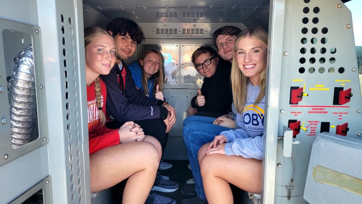 Seniors Emily Brundege, Gavin Kiser, Madison Luinstra, Bronalea Thies, Tanner Ray and James Barnett pose in the back of an old police van. The tour of the jail included seeing emergency vehicles. 