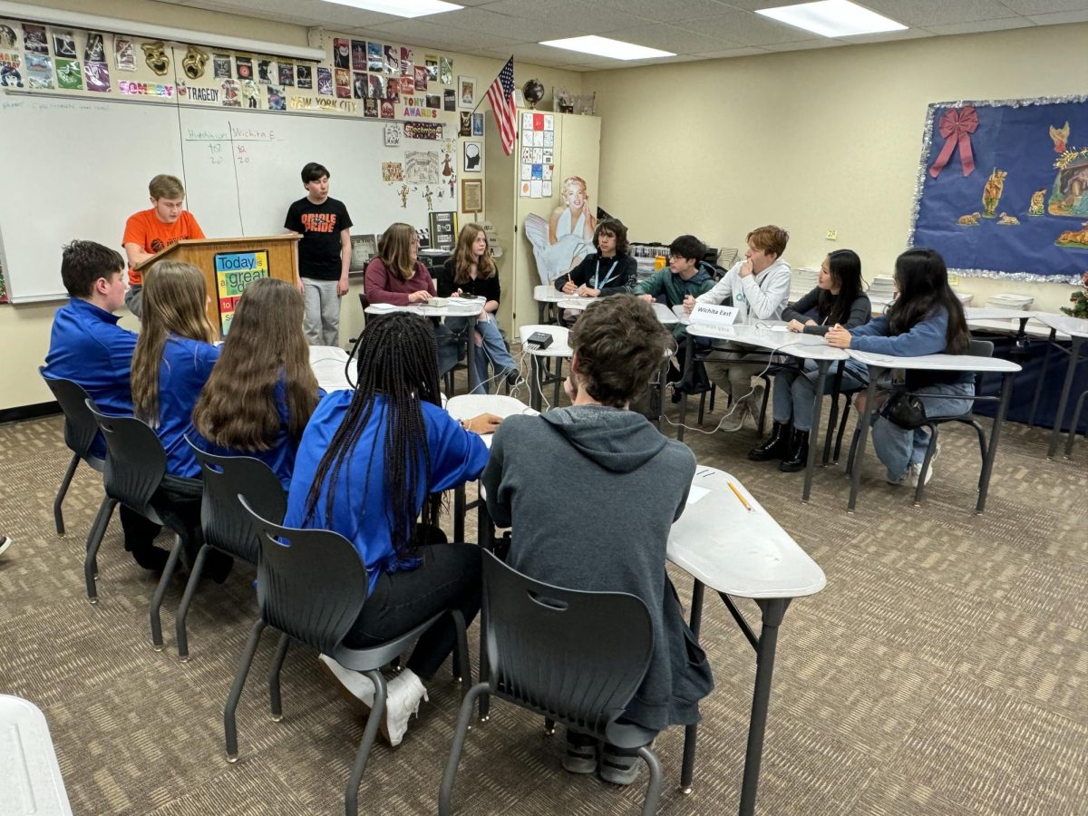 Junior Devon Stamback and sophomore Corbin Shillinger moderate a scholars bowl match during a JV tournament the team hosted. This match is between Hutchinson and Wichita East. 