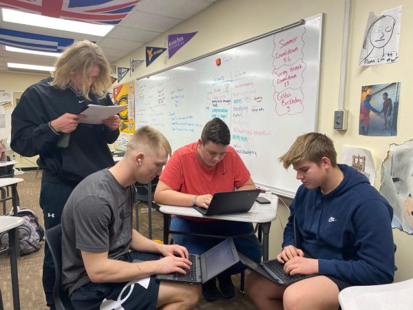 Juniors Landen Highbarger, Gabe Kohls, Emmett Brown and Brady Green work on their projects in junior AVID teacher Brad Raine’s class. Their research is based on the idea of bringing a service-learning based class to the high school.