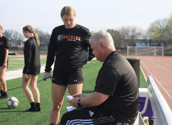 Dad and daughter duo senior Peyton Childers and business teacher Matt Childers talk about the starting line up for soccer. Peyton was in her dad’s carrer exploration class first semester. 