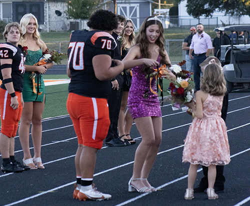 Homecoming queen Ella Strohm accepts the medal to place on homecoming king Willy Jon Morales. Strohm receives a tiara in return. 