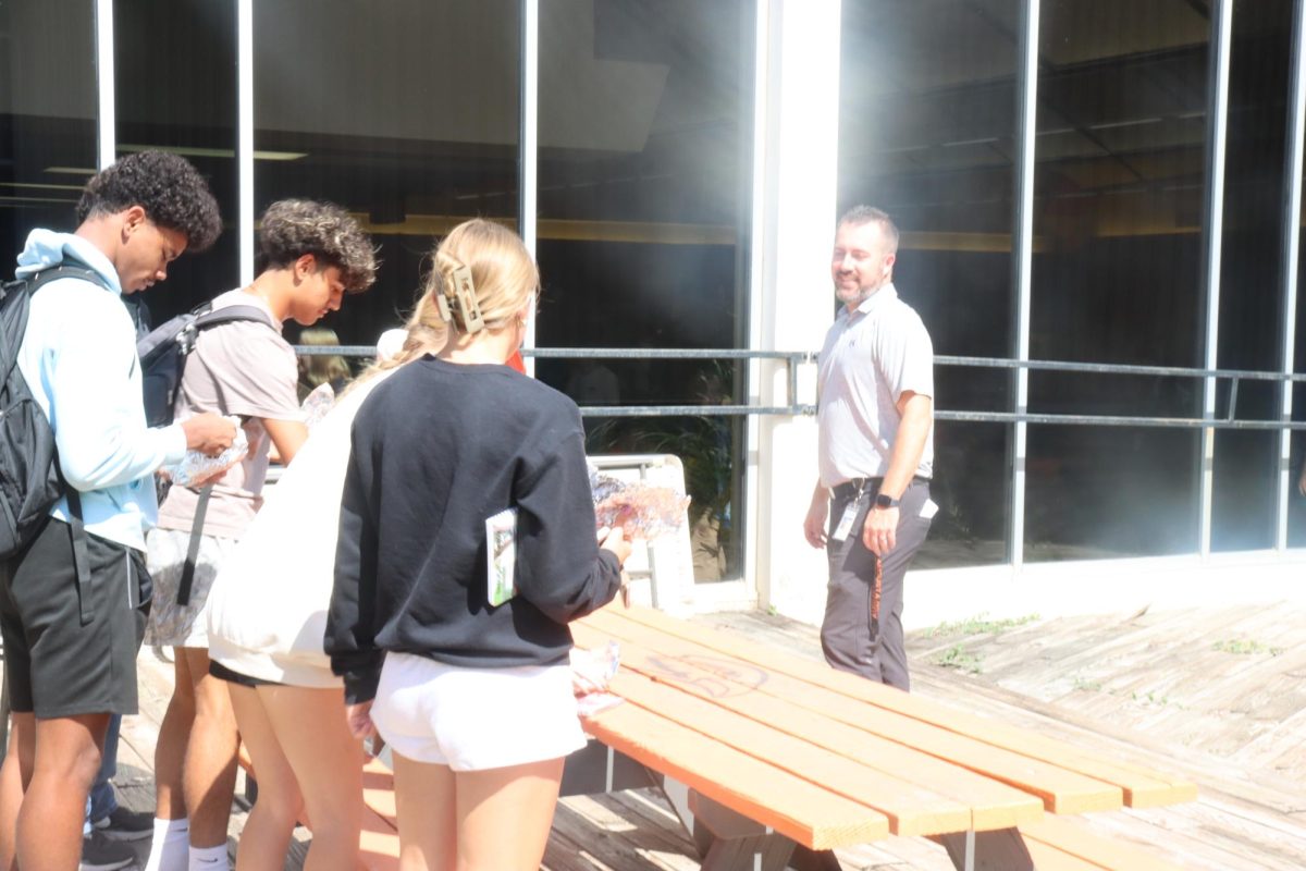 Principal T.J. Meyer watches students make hotdogs during lunch. Meyer values a positive connection with students.