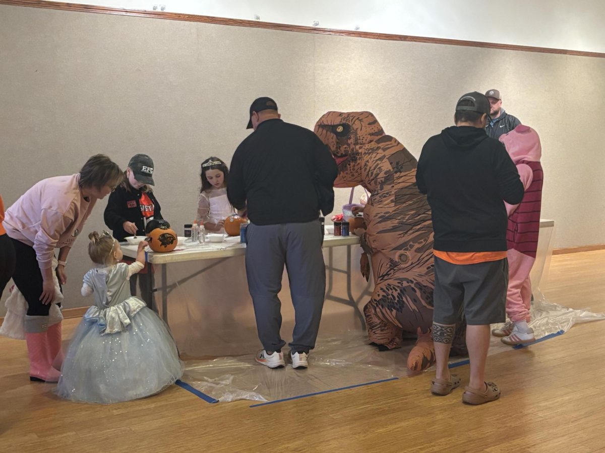 Children paint pumpkins at Trick or Treat Street. The rain made them move the activity inside.